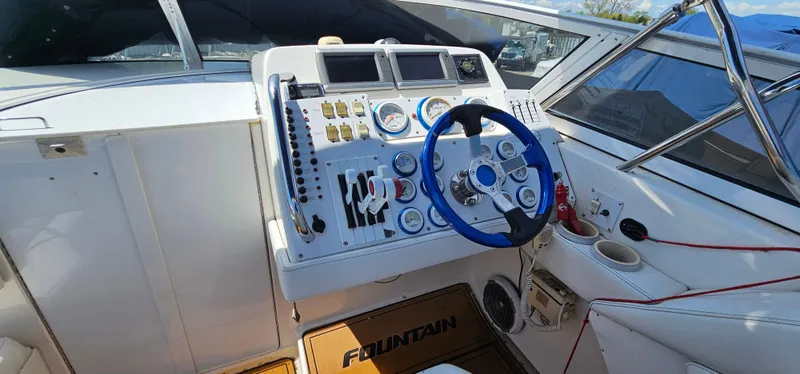 Slide: The Image of Cockpit of 2002 Fountain 38 Express Cruiser with steering wheel and control panel. - 14