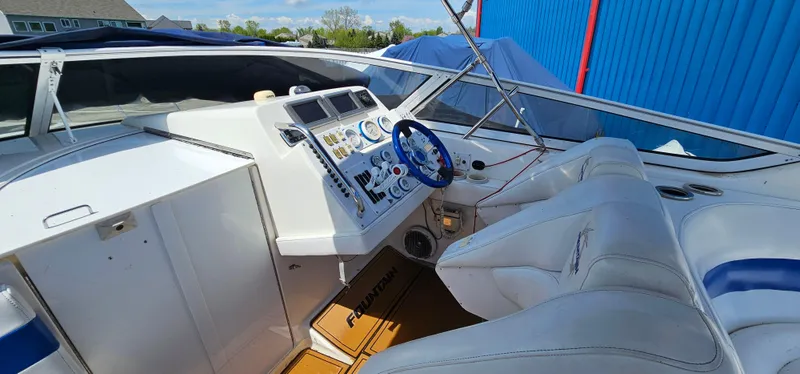 Slide: The Image of 2002 Fountain 38 Express Cruiser cockpit with white seating and blue steering wheel. - 15
