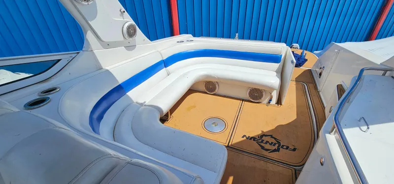 Slide: The Image of 2002 Fountain 38 Express Cruiser interior with white and blue seating, tan flooring, and speakers. - 18