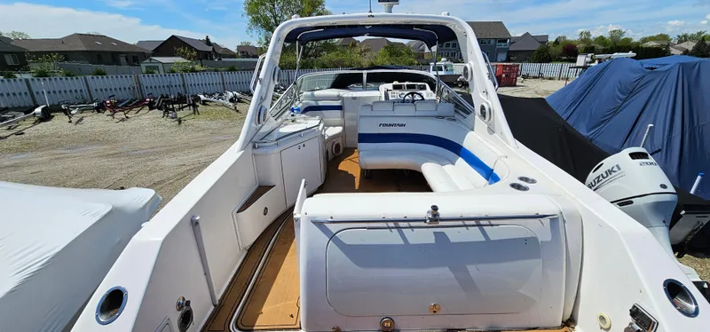 Slide: The Image of 2002 Fountain 38 Express Cruiser with spacious deck and seating, docked outdoors. - 22