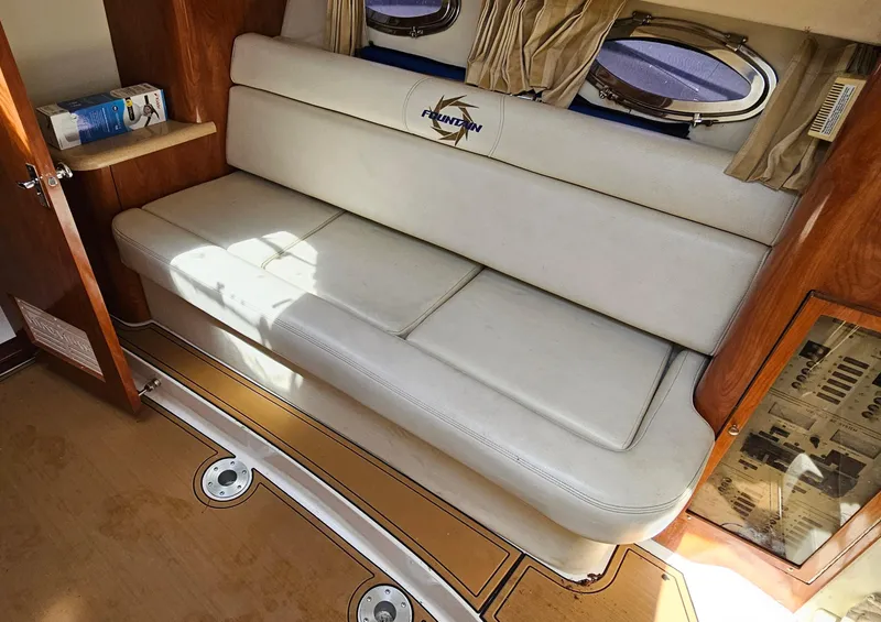 Slide: The Image of Interior of 2002 Fountain 38 Express Cruiser with white leather seating and wooden accents. - 26