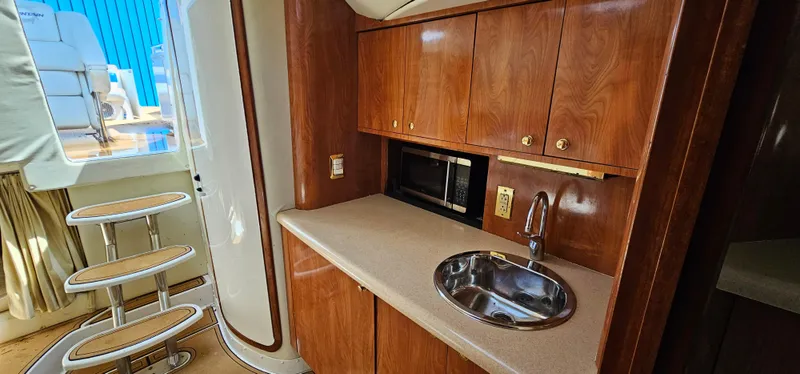 Slide: The Image of 2002 Fountain 38 Express Cruiser interior with kitchenette, sink, and wooden cabinetry. - 28