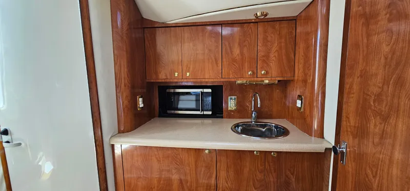 Slide: The Image of 2002 Fountain 38 Express Cruiser interior with wood cabinetry, sink, and microwave. - 29