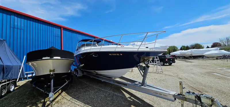 Slide: The Image of 2002 Fountain 38 Express Cruiser on trailer beside blue building under clear sky. - 3