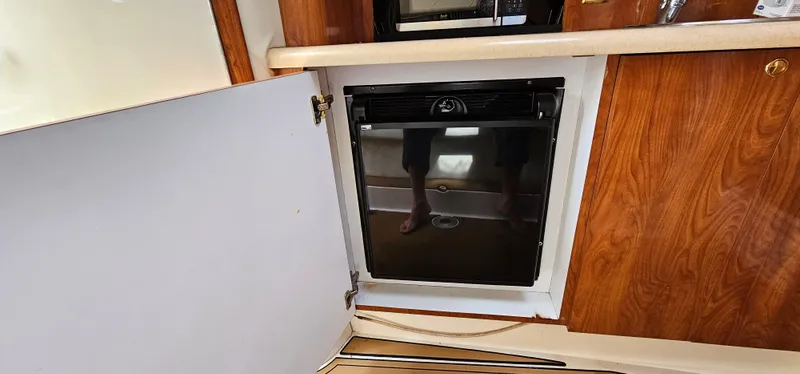 Slide: The Image of 2002 Fountain 38 Express Cruiser interior with wooden cabinetry and built-in mini fridge. - 30