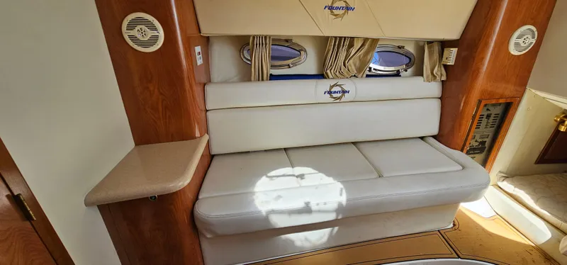 Slide: The Image of Interior of 2002 Fountain 38 Express Cruiser with white seating and wooden accents. - 33
