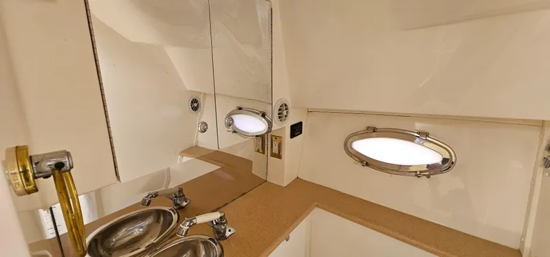 Slide: The Image of 2002 Fountain 38 Express Cruiser bathroom with oval porthole, mirror, and stainless steel sink. - 38