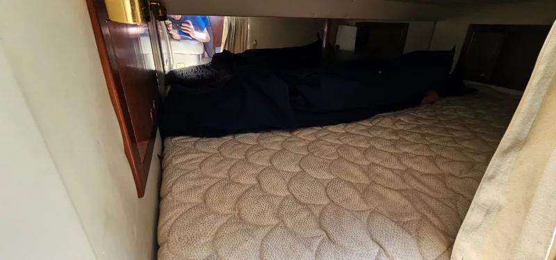 Slide: The Image of 2002 Fountain 38 Express Cruiser cabin with a cozy bed and wooden accents. - 44