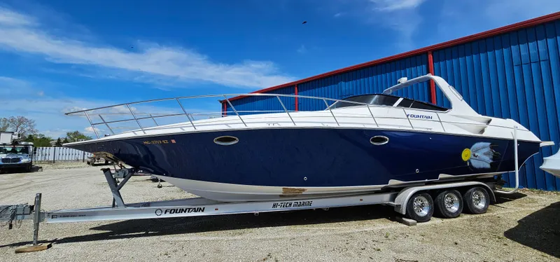 Slide: The Image of 2002 Fountain 38 Express Cruiser on trailer, parked outdoors under blue sky. - 6