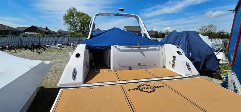 Slide: The Image of 2002 Fountain 38 Express Cruiser docked, covered, with clear sky background. - 8