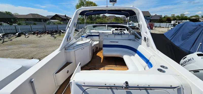 Slide: The Image of 2002 Fountain 38 Express Cruiser with spacious deck and seating, docked outdoors. - 9