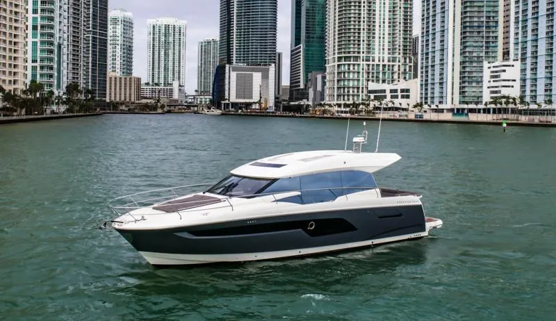 Slide: The Image of 2019 Prestige 520S yacht cruising in urban waterfront with skyscrapers in background. - 1