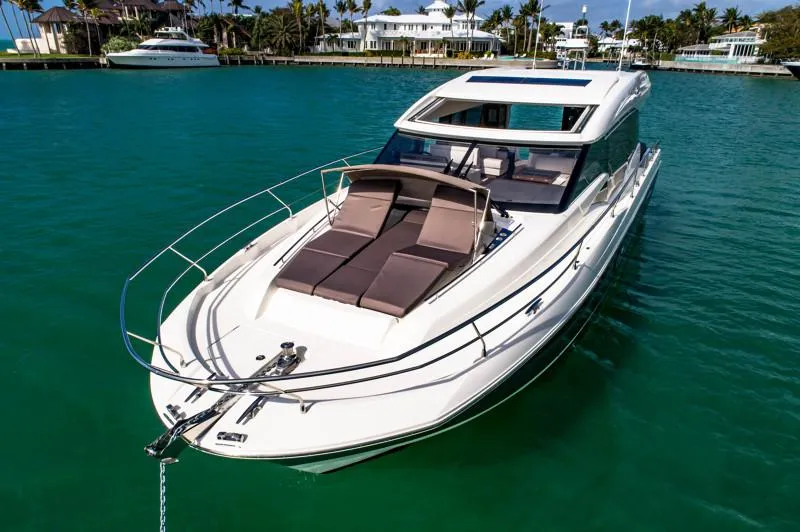 Slide: The Image of 2019 Prestige 520S yacht on turquoise water, featuring sleek design and sunbathing area. - 12