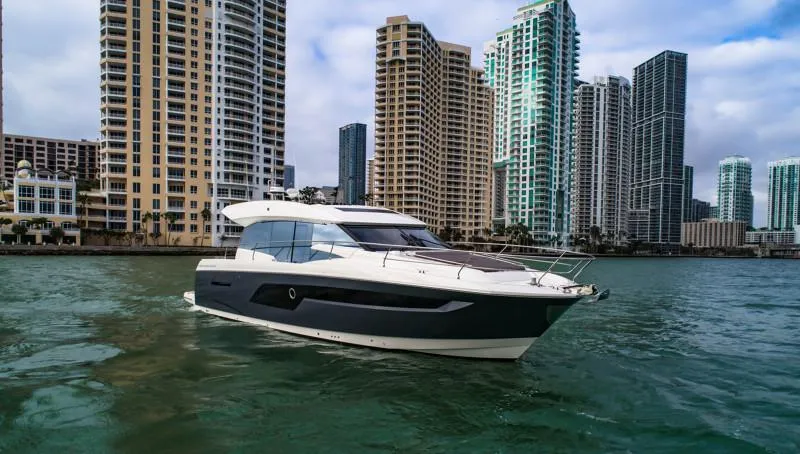 Slide: The Image of 2019 Prestige 520S yacht cruising near city skyscrapers on a sunny day. - 5
