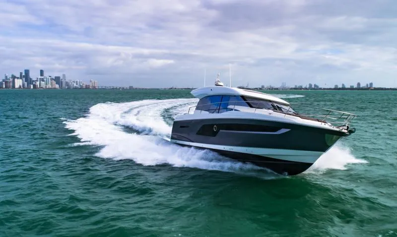 Slide: The Image of 2019 Prestige 520S yacht cruising on open water near city skyline. - 8
