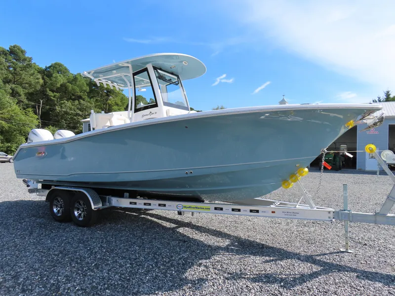 Slide: The Image of 2024 Sea Hunt Gamefish 25 boat on trailer, parked outdoors under clear blue sky. - 1