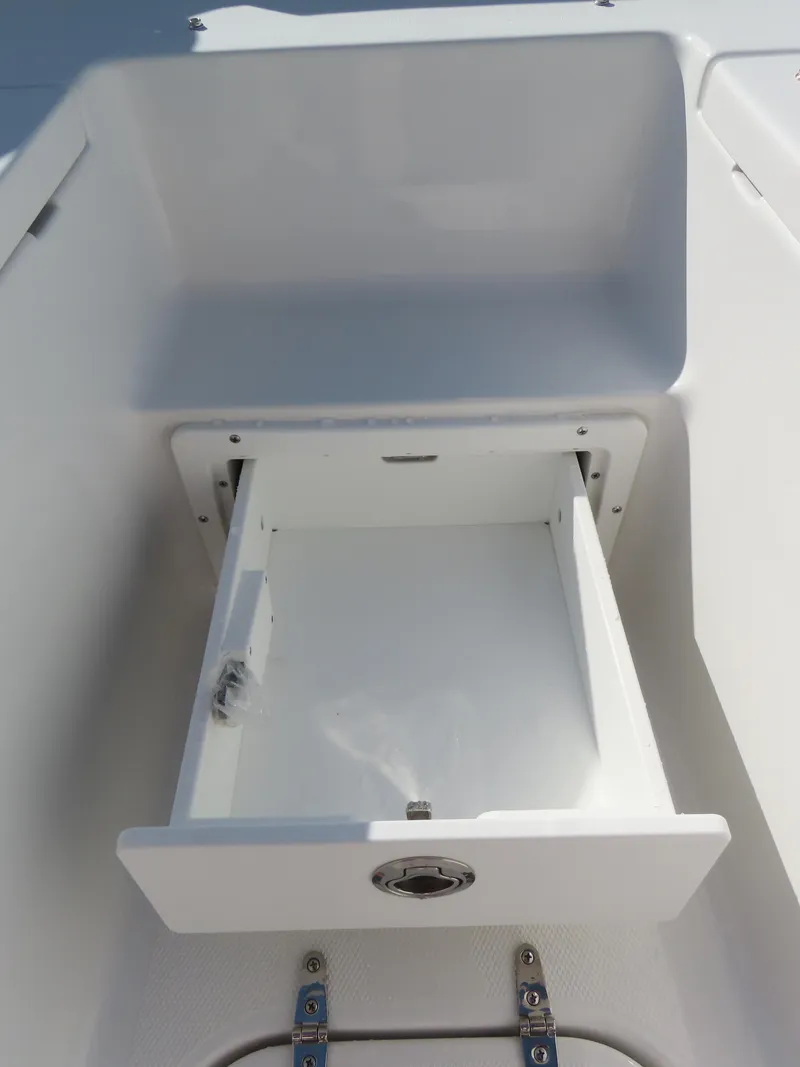 Slide: The Image of 2024 Sea Hunt Gamefish 25 storage compartment with open drawer, showcasing sleek design. - 14