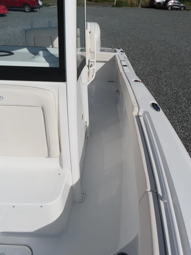 Slide: The Image of 2024 Sea Hunt Gamefish 25 boat, white interior, side view, parked on gravel. - 19