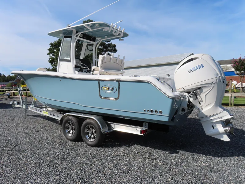 Slide: The Image of 2024 Sea Hunt Gamefish 25 boat on trailer with Yamaha engine, parked outdoors. - 3