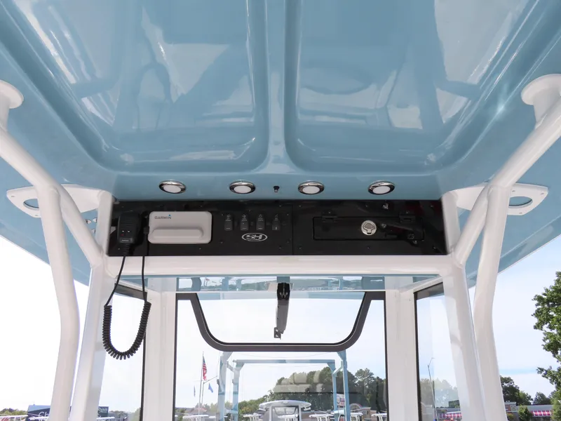 Slide: The Image of 2024 Sea Hunt Gamefish 25 boat console with electronics and blue canopy. - 30