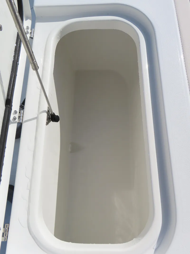 Slide: The Image of 2024 Sea Hunt Gamefish 25 storage compartment, open lid, white interior. - 38