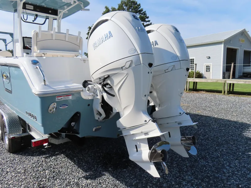 Slide: The Image of 2024 Sea Hunt Gamefish 25 with dual Yamaha outboard engines on a gravel driveway. - 4