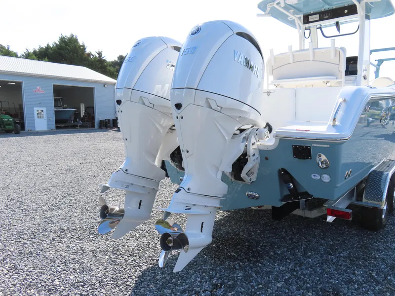 Slide: The Image of 2024 Sea Hunt Gamefish 25 with dual Yamaha outboard motors, parked on gravel. - 5
