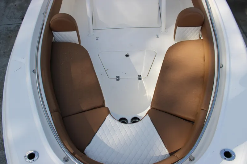 Slide: The Image of 2025 Pioneer 222 Islander boat interior with brown and white cushioned seating. - 10