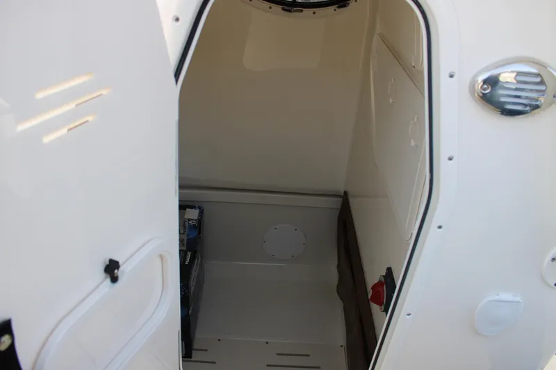Slide: The Image of 2025 Pioneer 222 Islander boat interior storage compartment, white finish, open door view. - 12