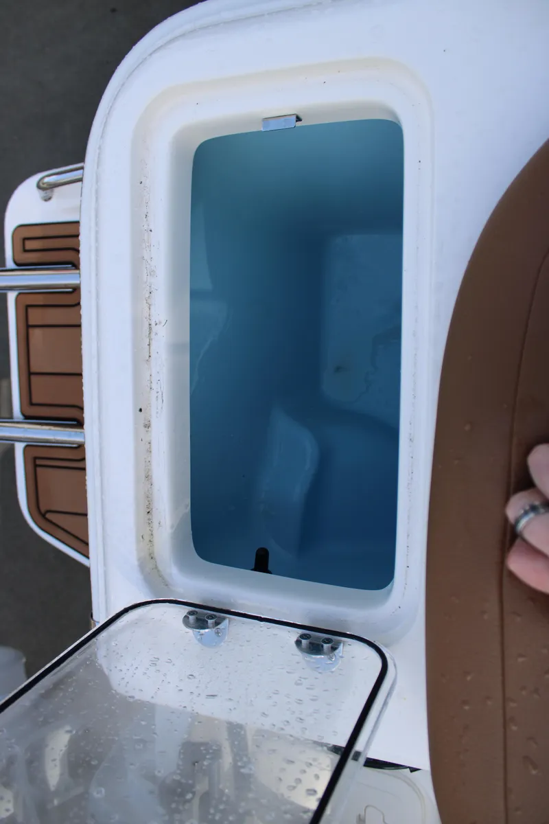 Slide: The Image of 2025 Pioneer 222 Islander boat storage compartment with open lid, showcasing interior space. - 16