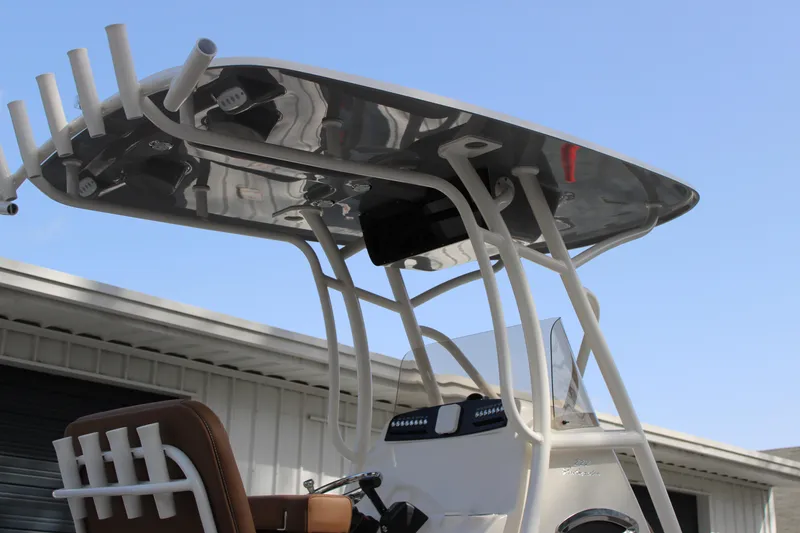 Slide: The Image of 2025 Pioneer 222 Islander boat with T-top and rod holders against blue sky. - 18