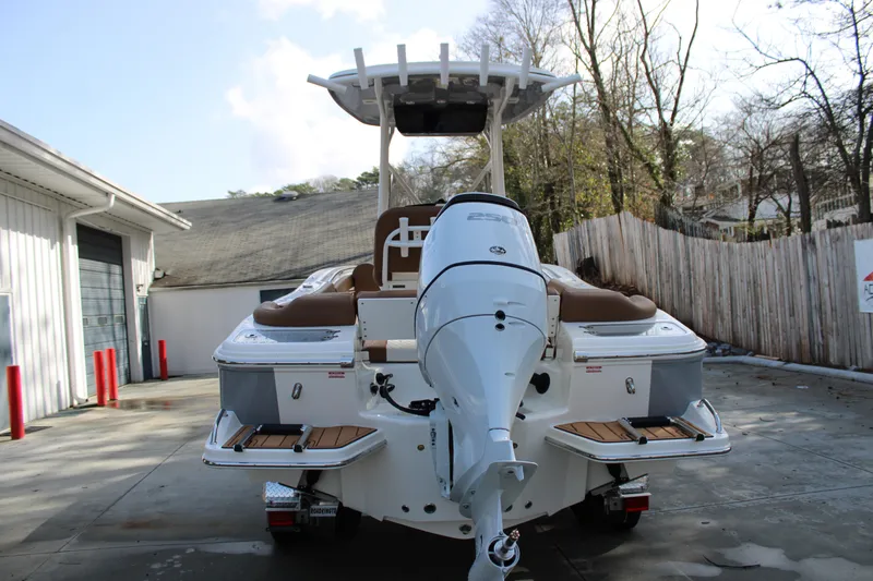 Slide: The Image of 2025 Pioneer 222 Islander boat with outboard motor, parked outdoors. - 4