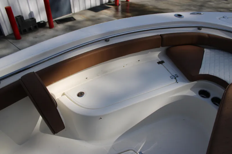 Slide: The Image of 2025 Pioneer 222 Islander boat interior with brown seating and white deck. - 6