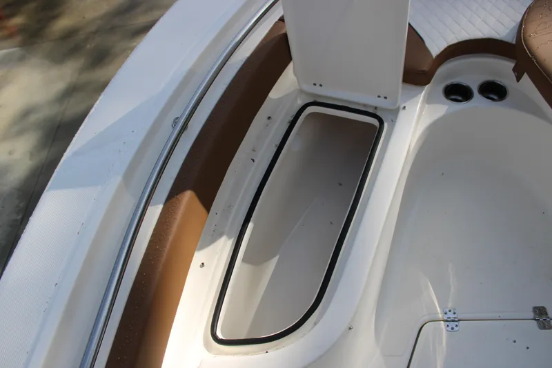 Slide: The Image of 2025 Pioneer 222 Islander boat storage compartment with brown and white interior design. - 7