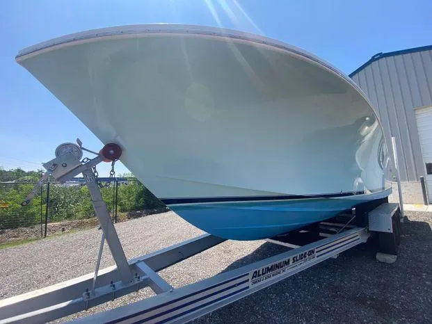 Slide: The Image of 2013 Regulator 28 Forward Seating boat on trailer, parked outdoors. - 3