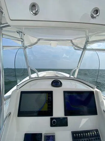 Slide: The Image of 2013 Regulator 28 Forward Seating boat dashboard with navigation screens on open water. - 4