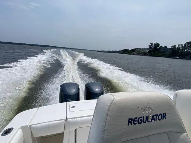 Slide: The Image of 2013 Regulator 28 Forward Seating boat cruising on open water, leaving a wake behind. - 5