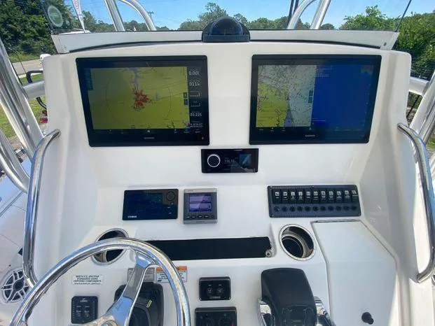 Slide: The Image of 2013 Regulator 28 Forward Seating boat dashboard with dual navigation screens and control panel. - 6