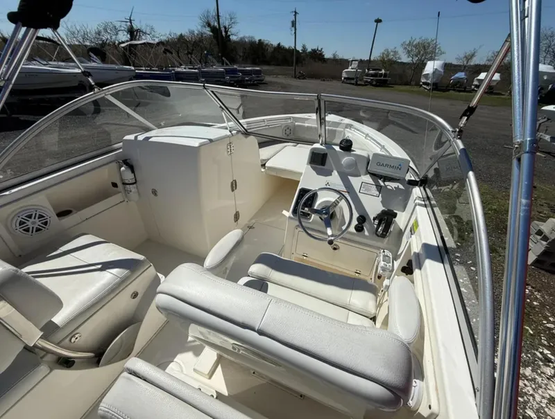 Slide: The Image of 2021 Cobia 220 Dual Console boat interior with steering wheel and seating. - 10
