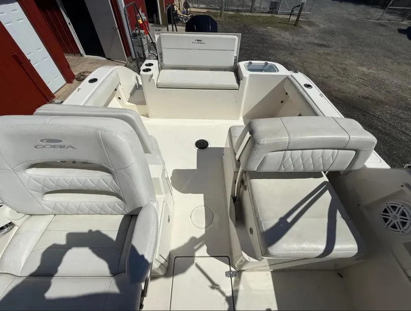 Slide: The Image of 2021 Cobia 220 Dual Console boat interior with white seating and storage compartments. - 12