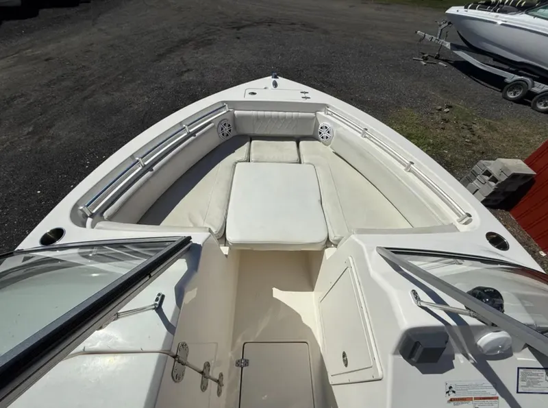 Slide: The Image of 2021 Cobia 220 Dual Console boat interior with white seating and storage compartments. - 13