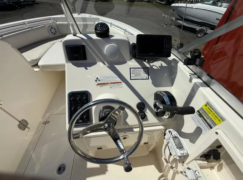 Slide: The Image of 2021 Cobia 220 Dual Console boat dashboard with steering wheel and navigation controls. - 15