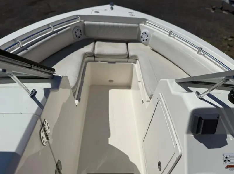 Slide: The Image of 2021 Cobia 220 Dual Console boat interior with cushioned seating and storage compartments. - 19