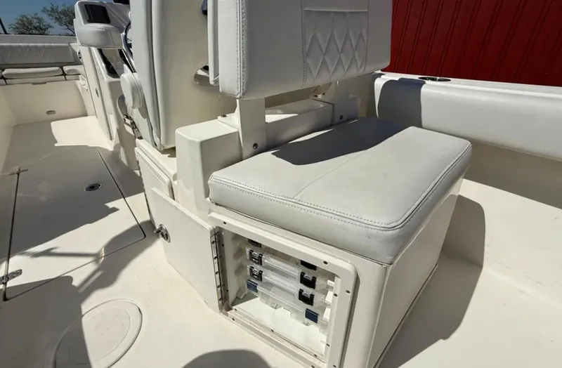 Slide: The Image of 2021 Cobia 220 Dual Console boat interior with white seating and storage compartment. - 20