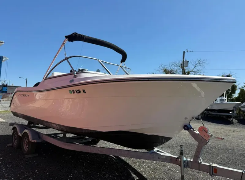 Slide: The Image of 2021 Cobia 220 Dual Console boat on trailer under clear blue sky. - 7