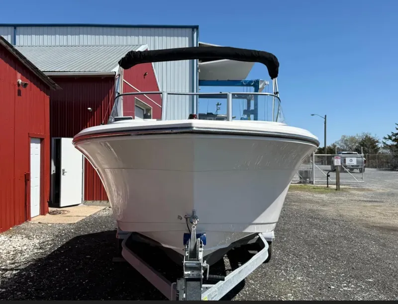 Slide: The Image of 2021 Cobia 220 Dual Console boat on trailer near red building. - 8