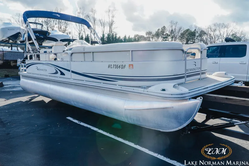 Slide: The Image of 2006 Bennington 2275 RL pontoon boat at Lake Norman Marina, parked on a trailer. - 2