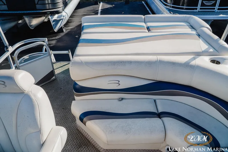 Slide: The Image of 2006 Bennington 2275 RL pontoon boat interior with white and blue seating at Lake Norman Marina. - 7