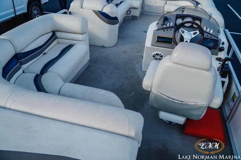 Slide: The Image of Interior of a 2006 Bennington 2275 RL pontoon boat with plush seating and a modern helm. - 8