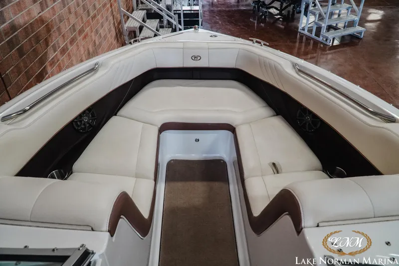 Slide: The Image of 2013 Cobalt 232 boat interior with white seating, brown accents, and carpeted flooring. - 13